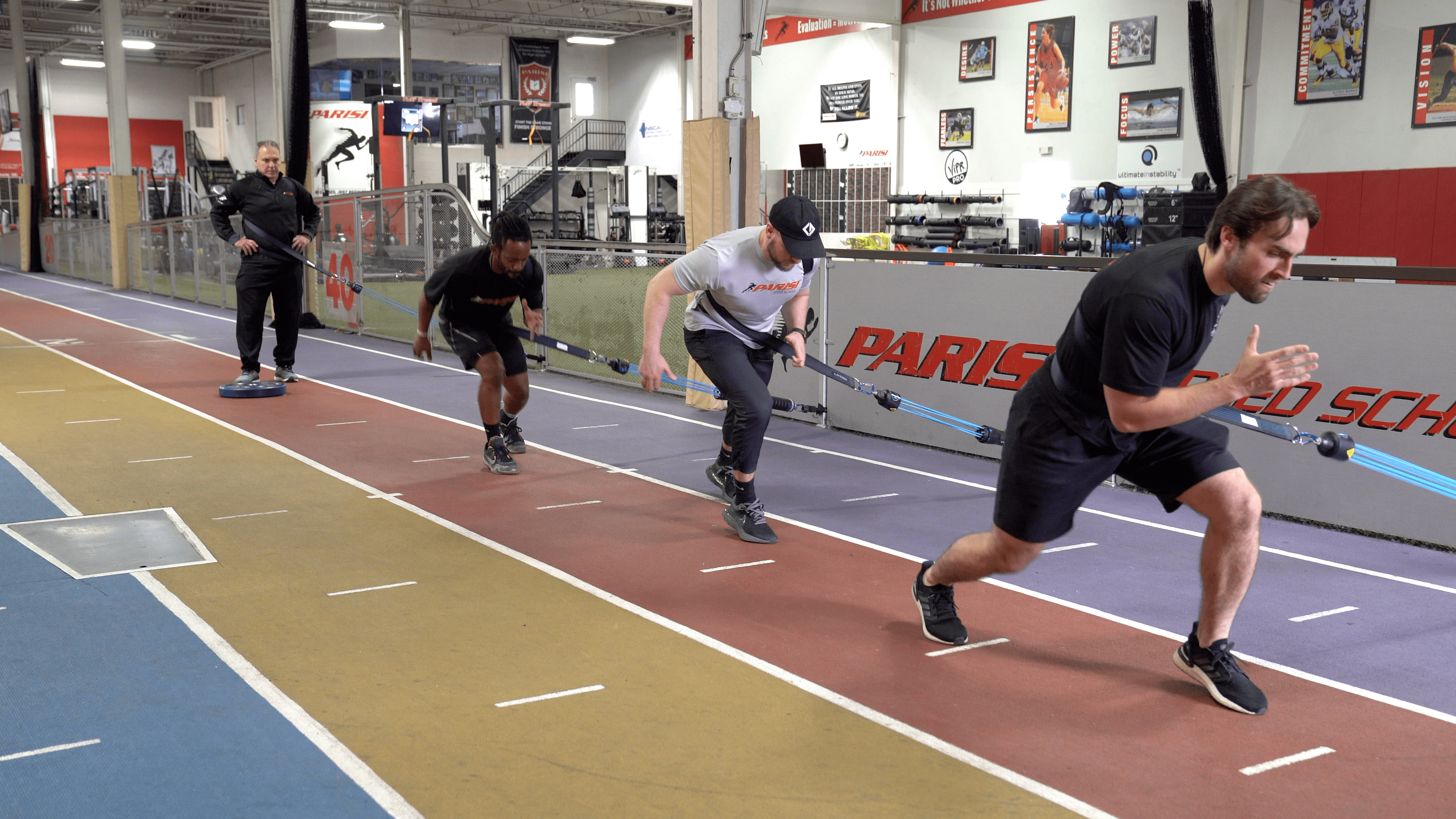 Group of athletes performing resistance band sprint drills to improve speed and agility